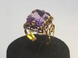 une bague en amethorate et en or posée sur un écrin noir