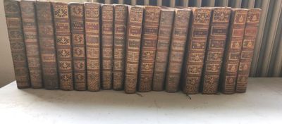 Plusieurs vieux livres sont alignés sur une étagère devant un radiateur