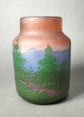 un vase avec un tableau posé sur une table