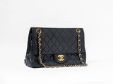 Sac Chanel noir à rabat en cuir d'agneau matelassé, avec finitions dorées