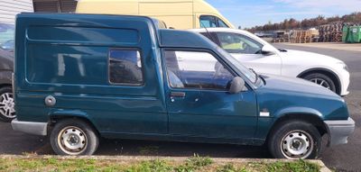 a blue van parked in a parking lot next to a white car