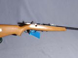 Le fusil est posé sur la table, avec un chapeau dessus.