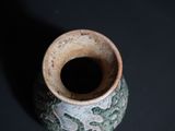 a small vase that is sitting on a black surface