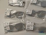 six pairs of sunglasses are wrapped in plastic bags on a table