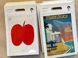 two apple stickers sitting on a table next to each other