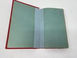 an open book with a red cover sitting on top of a white table