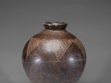 a brown vase sitting on top of a wooden stand