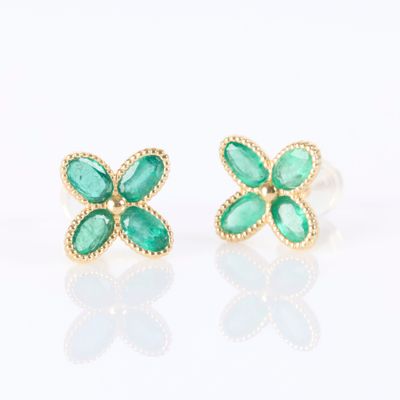 a pair of emerald and gold earrings on a white background
