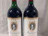 two bottles of red wine sitting next to each other on a table