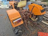 an orange tractor that is parked in a lot
