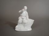 a figurine of a man sitting on top of a rock