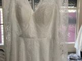 the back of a wedding dress hanging on a hanger in a bridal shop