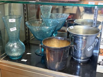 a glass display case filled with glass vases and bowls