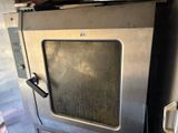 a metal oven with a glass door in a garage