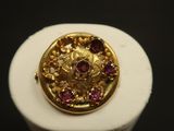 Gros plan sur une bague en or ornée de pierres roses