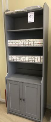 une bibliothèque avec un meuble et une porte, placée dans un coin