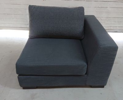 a blue chair with a pillow on it in a room