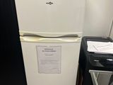 a white refrigerator with a sign on it next to a chair