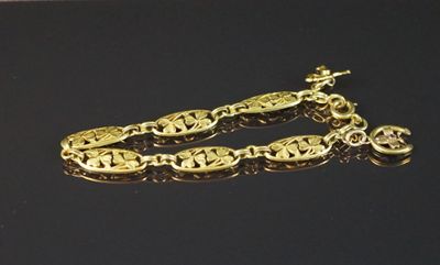gros plan d'un bracelet en or sur une surface noire