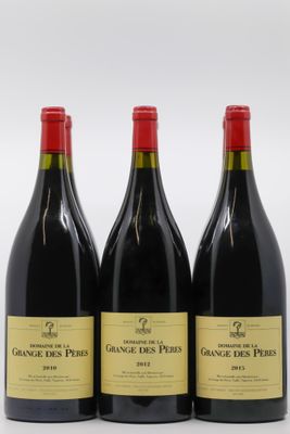 trois bouteilles de vin rouge sont alignées sur une surface blanche