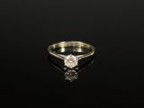 gros plan d'une bague en diamant sur une surface noire
