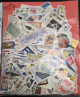 un sachet de timbres posé sur une table, sur fond rouge