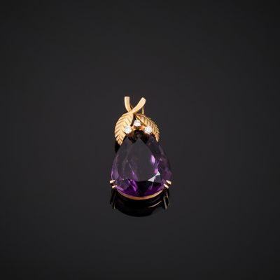 an amethorate and gold pendant with a bee on it