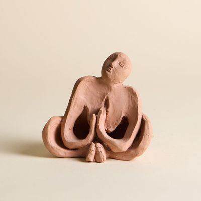 figurine en argile représentant une femme assise en position du lotus