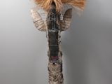 a tall vase with a bird on top of it