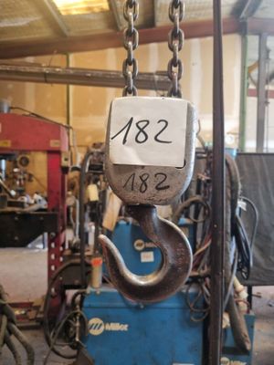 une photo d'une grue suspendue à un crochet dans un garage