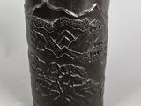 a black cup with a pattern on it on a table