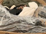 a cardboard box that has a bunch of clothes inside of it