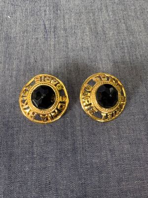 une paire de boucles d'oreilles dorées ornées de pierres noires
