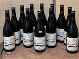 bottles of wine are lined up on a barrel on a table