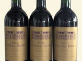 trois bouteilles de vin posées sur une table l'une à côté de l'autre