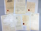 several old papers and a wax seal sitting on top of a table