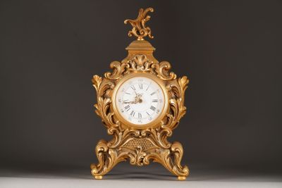 a gold clock sitting on top of a white table