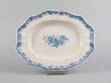 a blue and white plate with a flower design on it