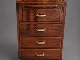 a small wooden chest of drawers with brass handles