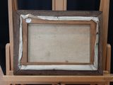 an old picture frame sitting on top of a wooden easel