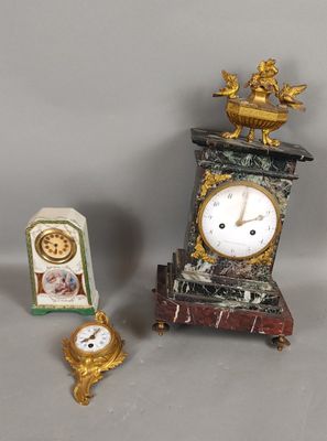 a small clock sitting next to a small clock on a table