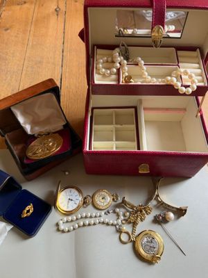 a red case with a bunch of jewelry inside of it