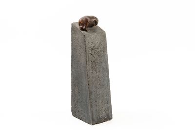 statue of a dog sitting on top of a cement block