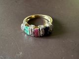 une image représentant une bague ornée de pierres multicolores