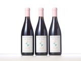 three bottles of wine are lined up on a table