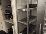 a kitchen with a metal shelving and lots of shelves