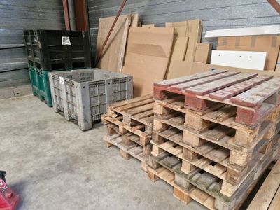 Plusieurs palettes de bois sont empilées dans un entrepôt