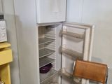 a refrigerator and a chair in a small room