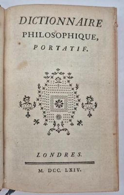 un vieux livre sur lequel est dessinée une croix, posé sur une table