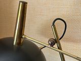 a close up of a black lamp on a table next to a wall